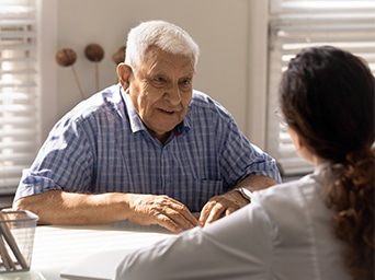 A man sitting at a table across of a woman