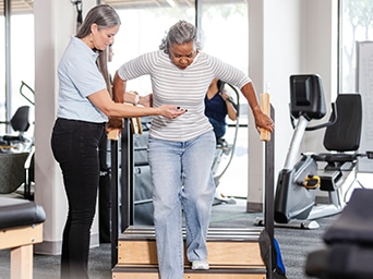 A woman walking down stairs with the help of another woman